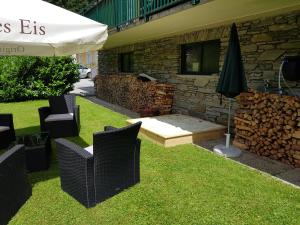 a patio with chairs and an umbrella next to a building at Feriendomizil Wetzelberger in Mönichwald