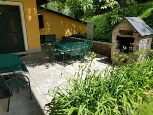 eine Terrasse mit einem Tisch, Stühlen und einem Kamin in der Unterkunft Feriendomizil Wetzelberger in Mönichwald