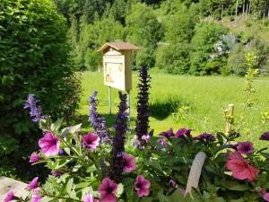 a garden with a bird house and flowers at Feriendomizil Wetzelberger in Mönichwald