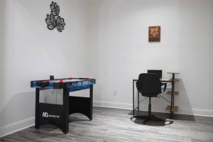 a ping pong table and a chair in a room at Remodeled luxury with Proximity in Lewisville