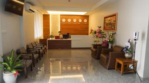 a lobby with a waiting room with a desk and chairs at Yangon Win Hotel in Yangon