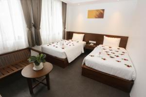 Un pat sau paturi într-o cameră la Yangon Win Hotel