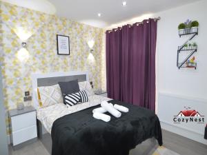 a bedroom with a bed with two towels on it at Luxury Central Self Contained Flat by CozyNest in Reading
