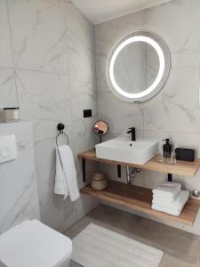 ein Badezimmer mit einem weißen Waschbecken und einem Spiegel in der Unterkunft Lazy 8 Villa in Garica