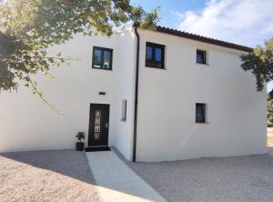 a white house with a black door at Lazy 8 Villa in Garica