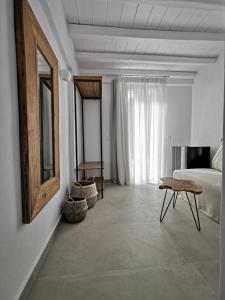 een slaapkamer met een bed, een tafel en een spiegel bij Sofos Suites Mykonos in Mykonos-stad