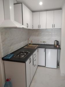 a kitchen with white cabinets and a sink and a stove at Аппартаменты студия первая линия у моря в Совиньоне in Odesa