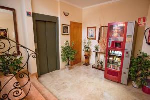 a room with a red refrigerator and potted plants at Hostal Miguel y Juani in L'Alcúdia