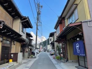 eine leere Straße in einer asiatischen Stadt mit Gebäuden in der Unterkunft 吹屋庵 in Takayama
