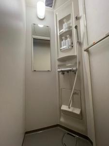 ein kleines Badezimmer mit Waschbecken und Spiegel in der Unterkunft 吹屋庵 in Takayama