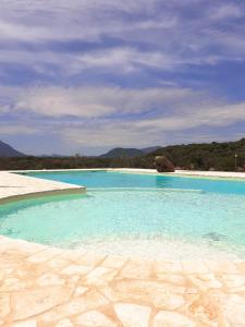 uma grande piscina de água azul numa praia em Agriturismo Muristene em Dorgali