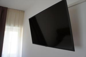 Ein Flachbildfernseher hängt an einer Wand neben einem Fenster. in der Unterkunft Vecchia Mori in Mori