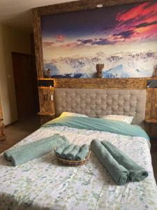 a bed with a painting on the wall at Auberge du Raddon in Raddon-et-Chapendu