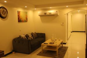 uma sala de estar com um sofá e uma mesa em الجناح الأبيض للأجنحه الفندقية em Dammam