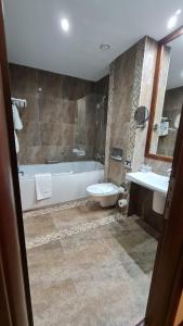 a bathroom with a tub and a toilet and a sink at Apartment Privat ApartHotel Alpin fara mic dejun si fara acces SPA in Poiana Brasov