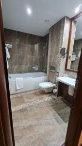 y baño con bañera, aseo y lavamanos. en Apartment Privat ApartHotel Alpin fara mic dejun si fara acces SPA, en Poiana Brasov