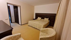 1 dormitorio con 1 cama y 1 silla en Apartment Privat ApartHotel Alpin fara mic dejun si fara acces SPA, en Poiana Brasov