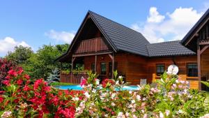a house with a swimming pool and flowers at Chata Dvě Sestry in Červená Voda