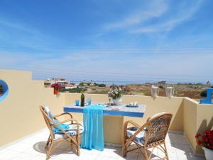 a patio with a table and chairs and the ocean at Malia Star Apartments in Malia
