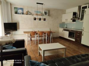 a kitchen and living room with a table and chairs at Landhof Schober appartementen in Weissbriach