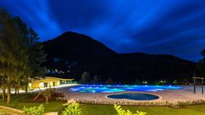 una grande piscina di notte con una montagna sullo sfondo di Sobe Janez a Križe