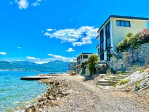克拉西奇Beachfront villa Pearl of Adria的水边岩石海滩上的建筑