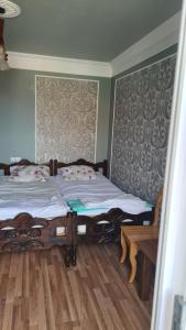 1 dormitorio con 1 cama y suelo de madera en Gios Guest House, en Chakvi