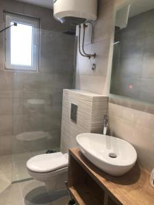 Un baño con un lavabo blanco y un inodoro. en Petivat Gardens, en Tivat 42 fotos más