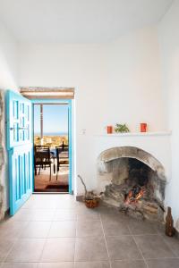 a living room with a fireplace and a patio at Ilias Cottage in Afiartis