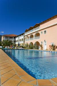 a large swimming pool next to a building at Hotel Plessas Palace in Alikanas