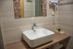 a bathroom with a white sink and a mirror at Benjamin Hotel in Kaštela