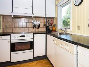 een keuken met witte apparatuur en een wastafel bij 6 person holiday home in R m in Kongsmark