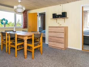 a dining room with a wooden table and chairs at 6 person holiday home in R m in Kongsmark