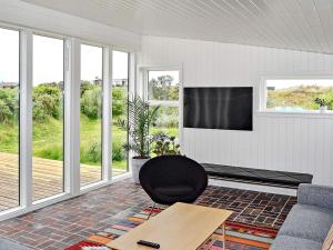 un soggiorno con TV e sedia di 5 person holiday home in Fan a Fanø