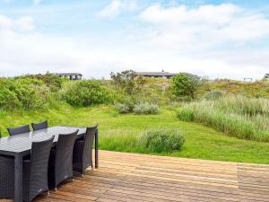 a wooden deck with a table and chairs at 5 person holiday home in Fan in Fanø