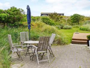 a table and two chairs and an umbrella at 5 person holiday home in Fan in Fanø