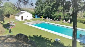 an overhead view of a swimming pool with people sitting around it at Casa de ls Cristales in Bemposta