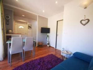 a living room with a blue couch and a table and chairs at Airport Garden Apartments in Čilipi