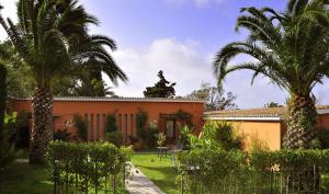 a house with two palm trees in a yard at Hotel Punta Sur in Tarifa