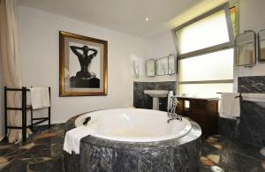a large bathroom with a large bath tub with a window at Hotel Punta Sur in Tarifa