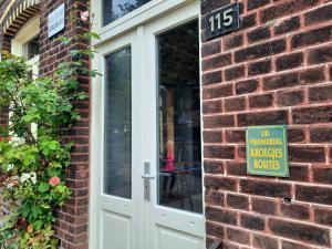 a sign on the side of a brick building with a no walking inspectors hours sign at Auberge A gen Kirk B&B in Vijlen