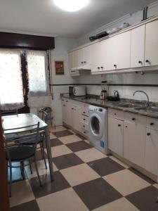 uma cozinha com uma mesa e uma máquina de lavar roupa em CHALET ADOSADO CON GARAGE Y TERRENO em Uruñuela