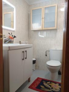 CHALET ADOSADO CON GARAGE Y TERRENO في Uruñuela: حمام مع حوض أبيض ومرحاض