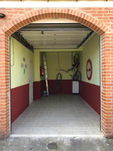 un garaje con una puerta abierta con una bicicleta en la pared en CHALET ADOSADO CON GARAGE Y TERRENO en Uruñuela