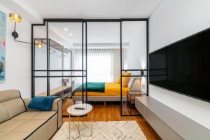 uma sala de estar com um sofá e uma televisão em SUITE LUJO CENTRO-NAUTICO-CIES+parking em Vigo