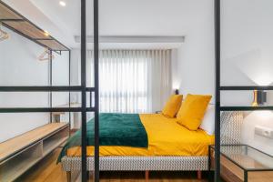ein Schlafzimmer mit einem Etagenbett mit gelber und grüner Bettwäsche in der Unterkunft SUITE LUJO CENTRO-NAUTICO-CIES+parking in Vigo
