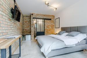 a bedroom with a bed and a brick wall at Pokoje LotNik nad jeziorem in Nikutowo