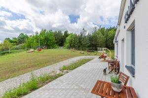 eine Terrasse mit Bänken und einen Park mit Spielplatz in der Unterkunft Pokoje LotNik nad jeziorem in Mrągowo