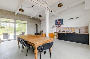 a kitchen and dining room with a wooden table and chairs at Pokoje LotNik nad jeziorem in Nikutowo