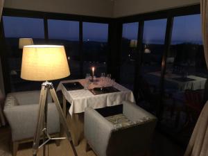 sala de estar con mesa, sillas y lámpara en Jbay Zebra Lodge, en Longmore